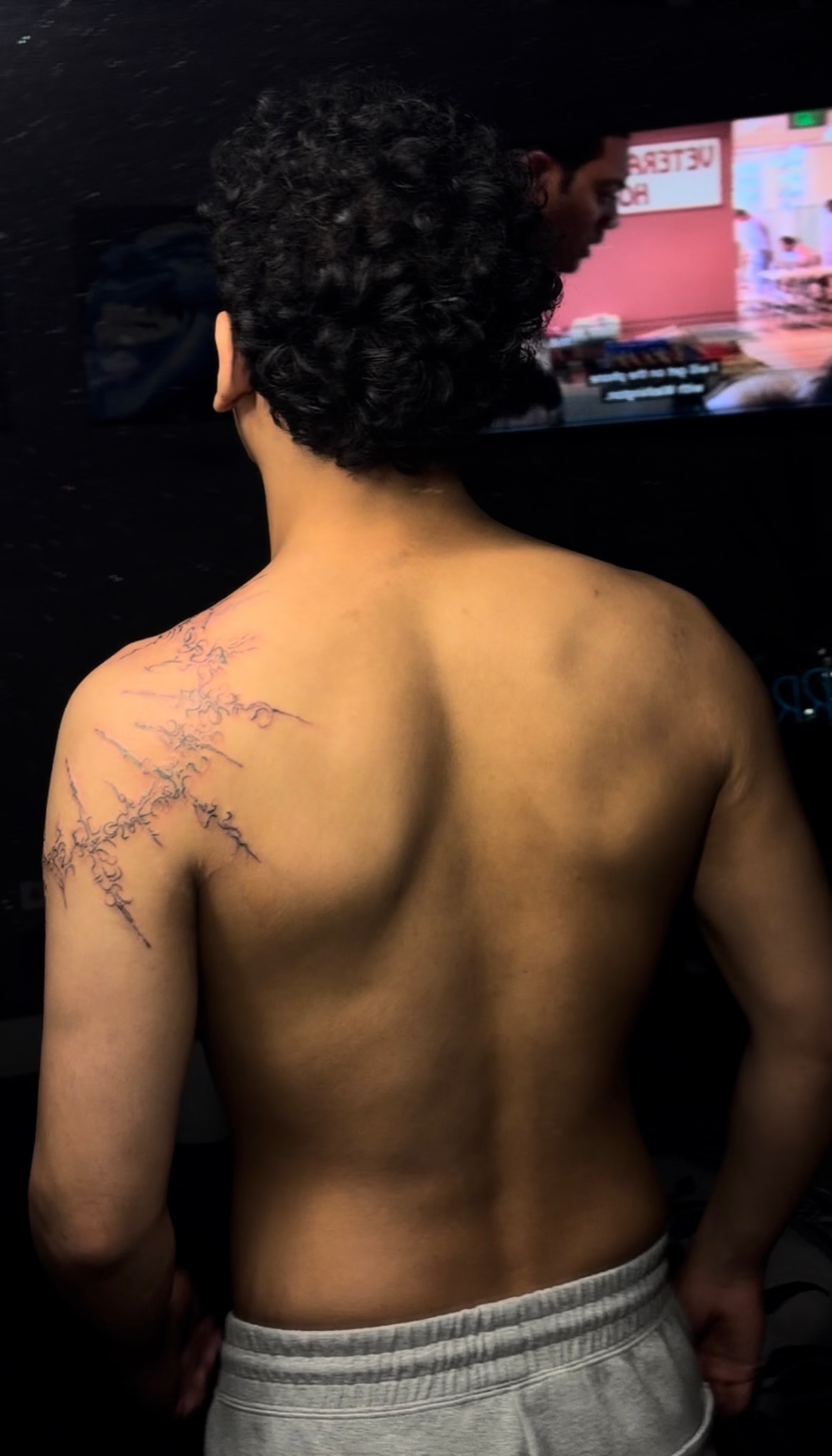 Fine line ornamental script tattoo over the shoulder