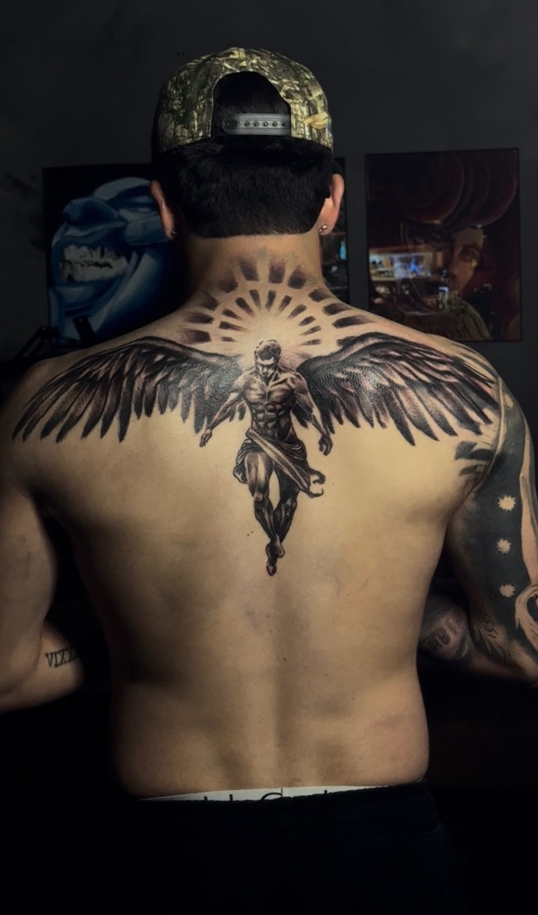 Guardian angel with wings tattoo across the upper back