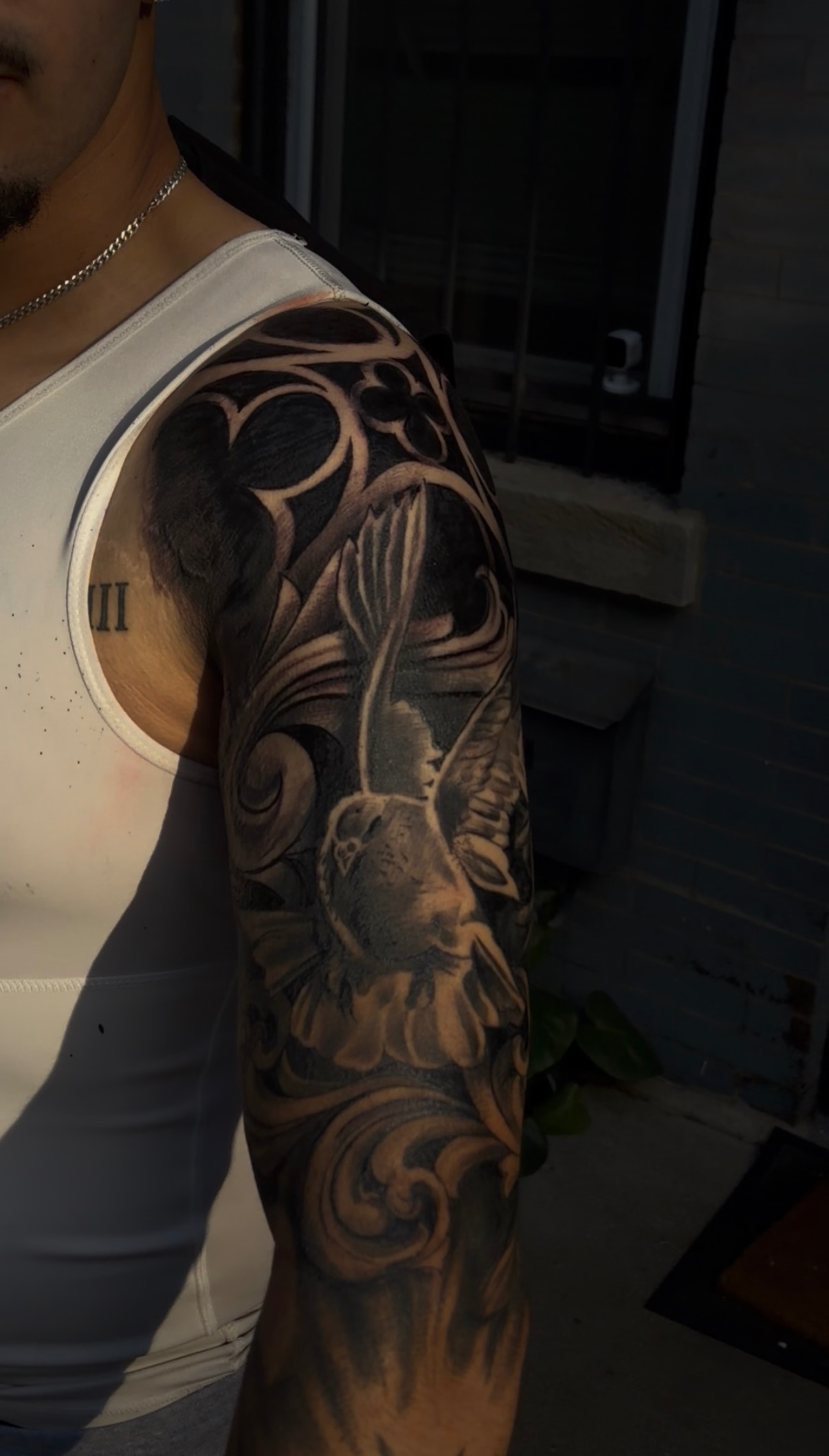 Hummingbird and filigree black and gray sleeve tattoo