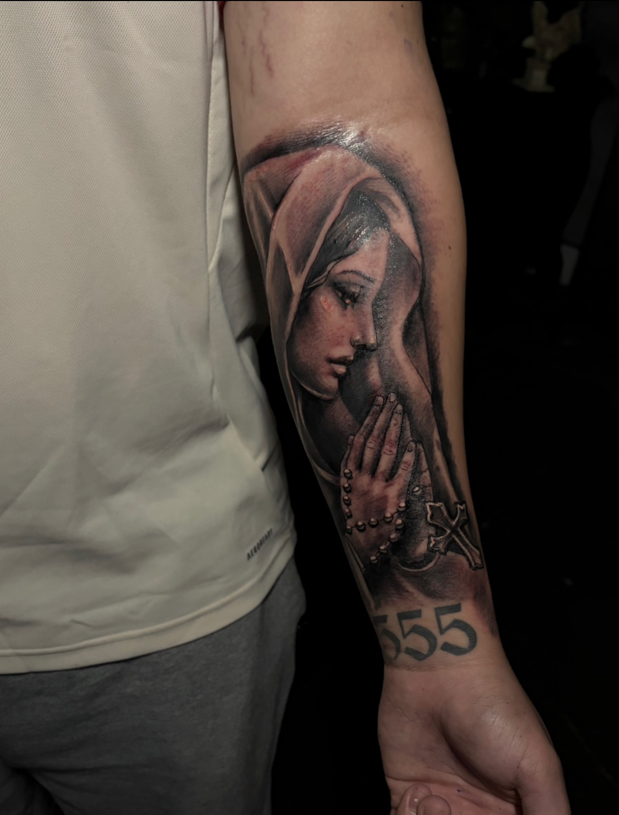 Virgin Mary praying with rosary forearm tattoo